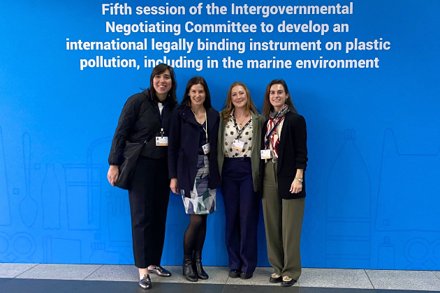 Common Seas INC-5 delegation in front of sign for the negotiation session in Busan, Korea. Large blue sign with white text.