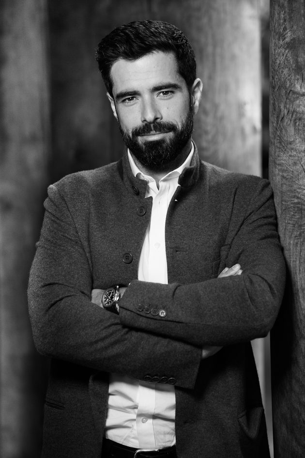 Profile photo of Filippos Lemos, Executive Advisor at Common Seas. Filippos wears a white shirt and dark jacket. He has his arms crossed and is looking at the camera. Photo is in greyscale.