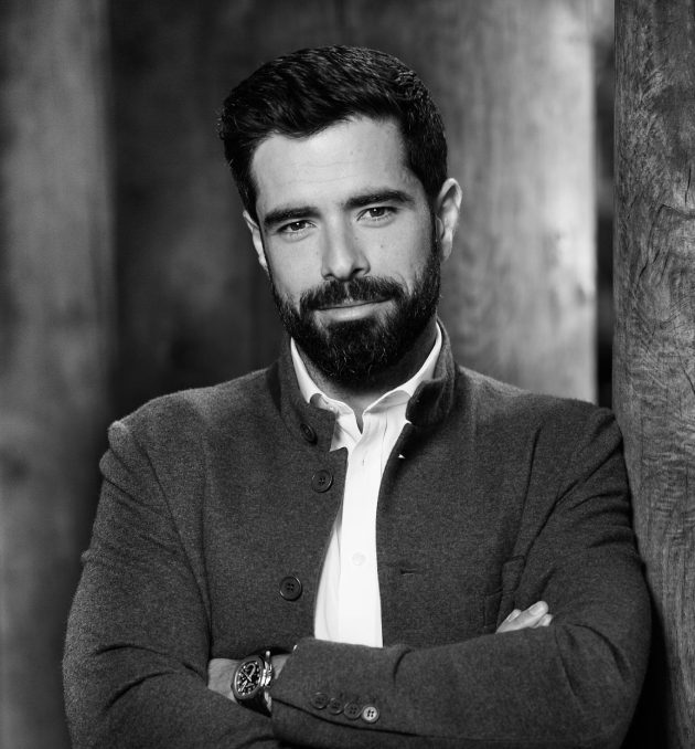 Profile photo of Filippos Lemos, Executive Advisor at Common Seas. Filippos wears a white shirt and dark jacket. He has his arms crossed and is looking at the camera. Photo is in greyscale.