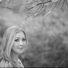 Profile photo of Emma Kai Thomas, Senior Communications Manager at Common Seas. Emma wears a striped jumper and smiles at the camera side-on. Photo is in greyscale.