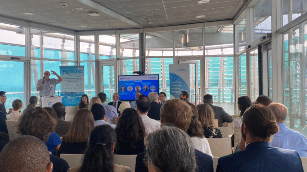 World Bank Group event - people inside in space overlooking city, with panel seated at front and screen behind with speaker images
