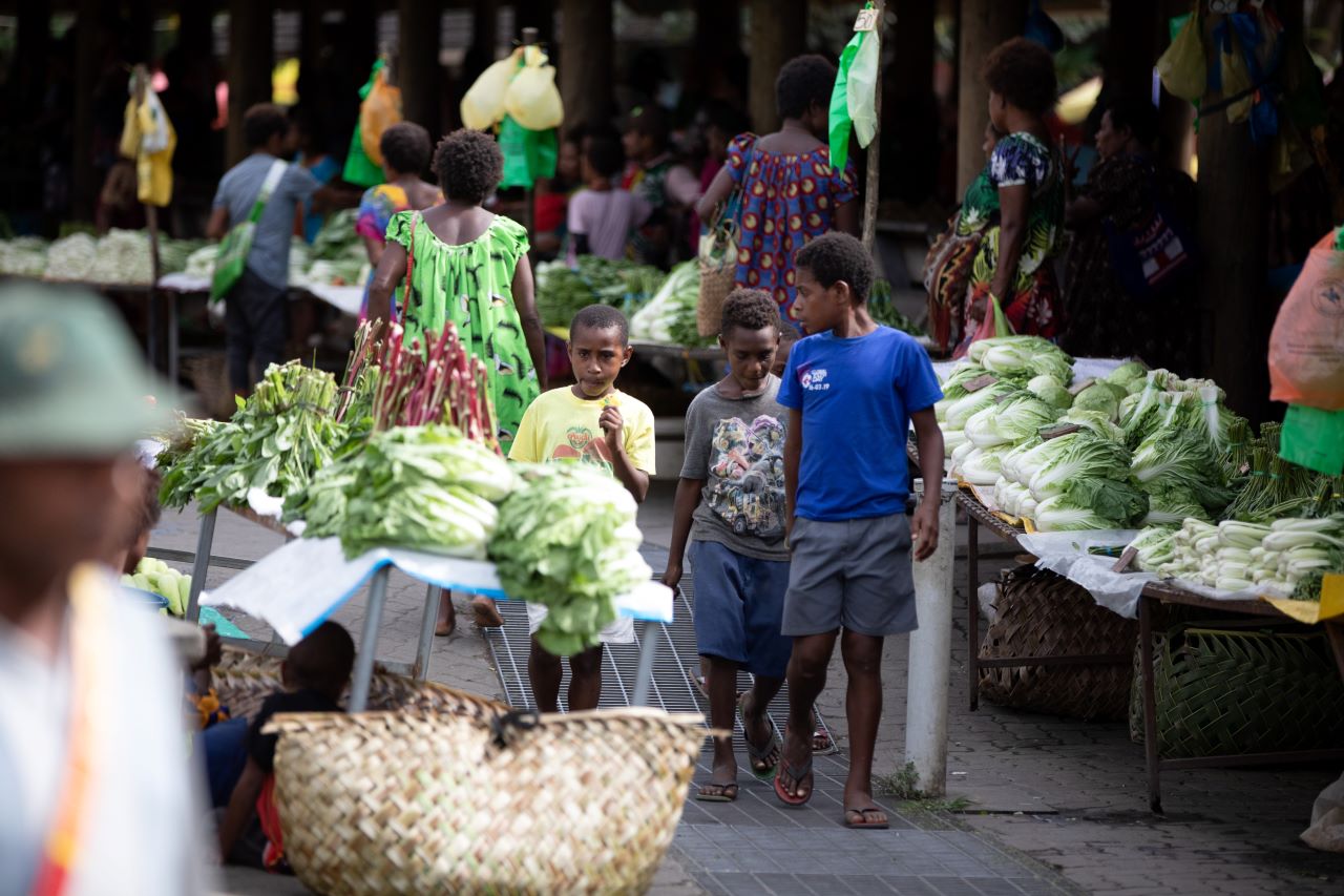 Papua New Guinea - children walking through Kokopo market
