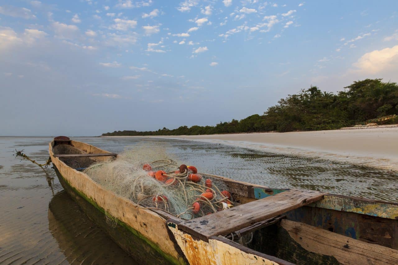 Traditional fishing canoe at the beach in the island of Orango at sunset, in Guinea Bissau.